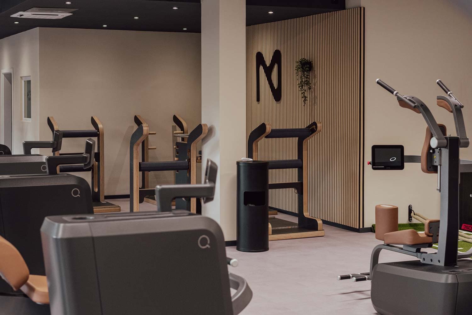 Trainingsbereich mit Holz-Akzentwand und Gerätepark